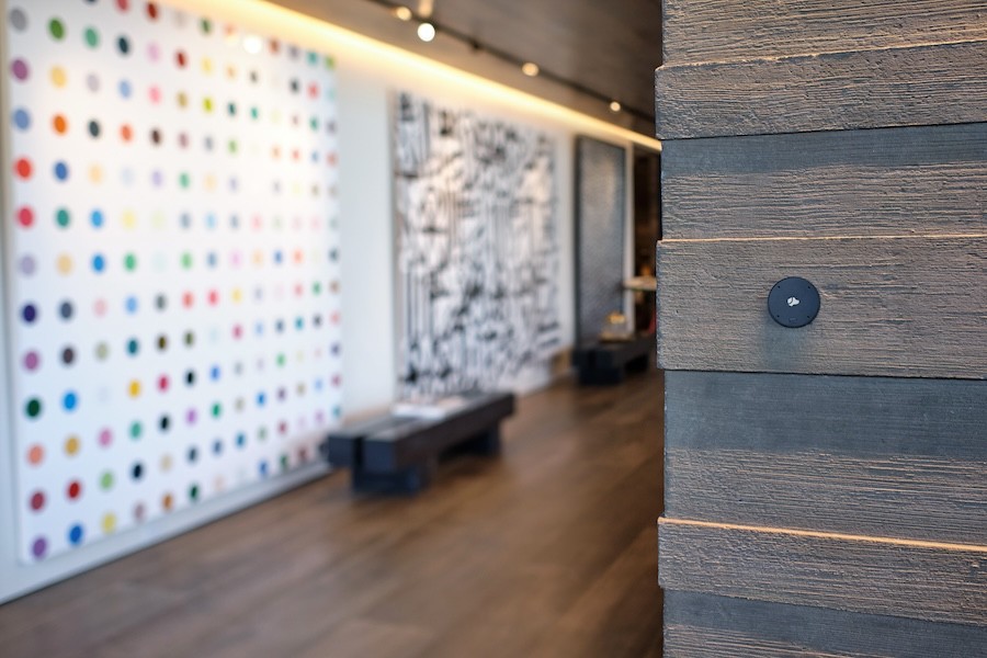 Josh Nano device mounted on a wall in a walkway.