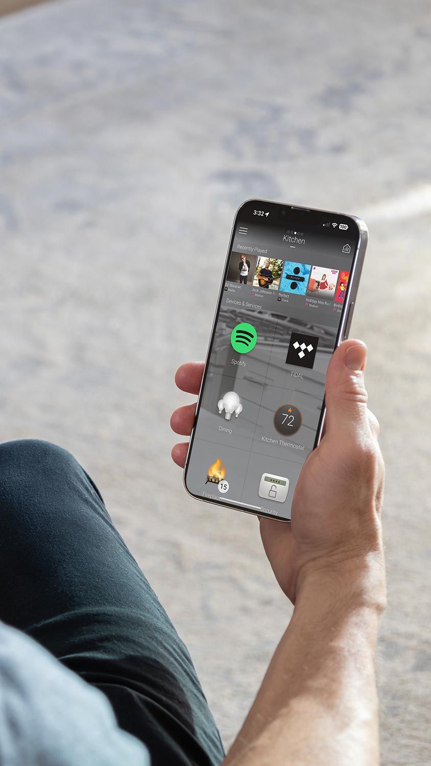 Man holding a smartphone showing a smart home app interface